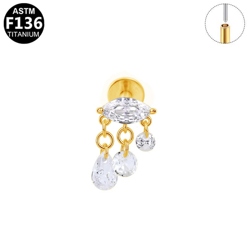 A gold-plated titanium stud earring with a marquise-cut clear crystal and three dangling teardrop-shaped clear crystals, shown on a white background with an inset diagram of the titanium post and an ASTM F136 badge.
