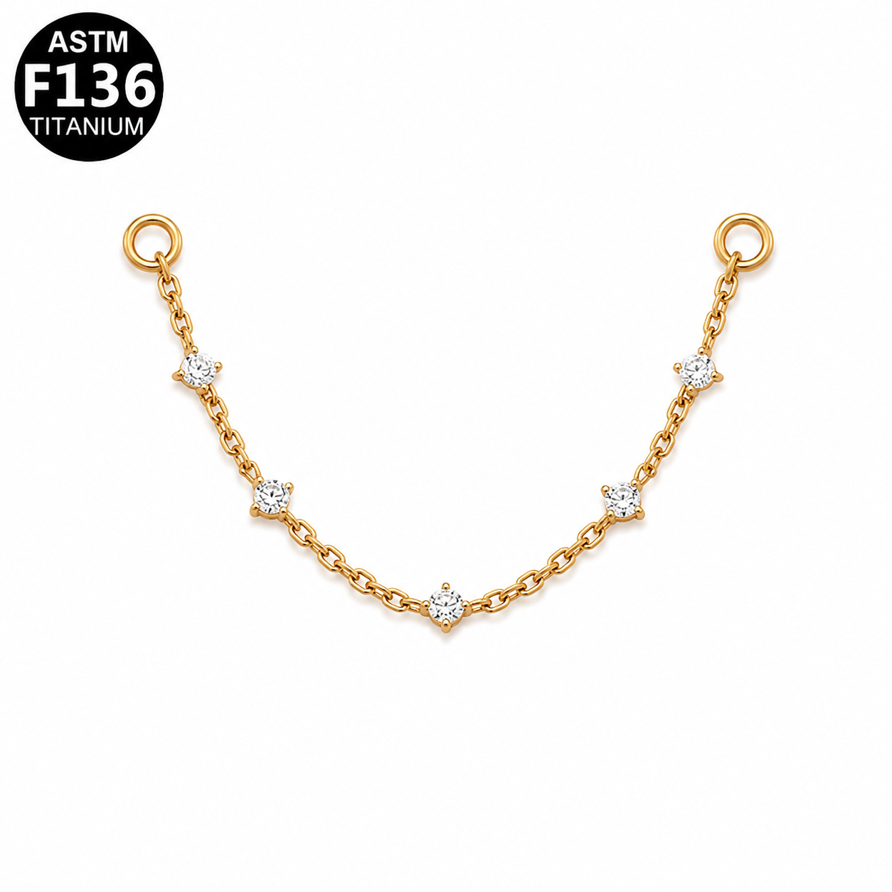 A gold chain bracelet with five small solitaire/star-shaped settings, each holding a clear round gemstone, displayed on a white background with an ASTM F136 Titanium badge in the top-left corner.