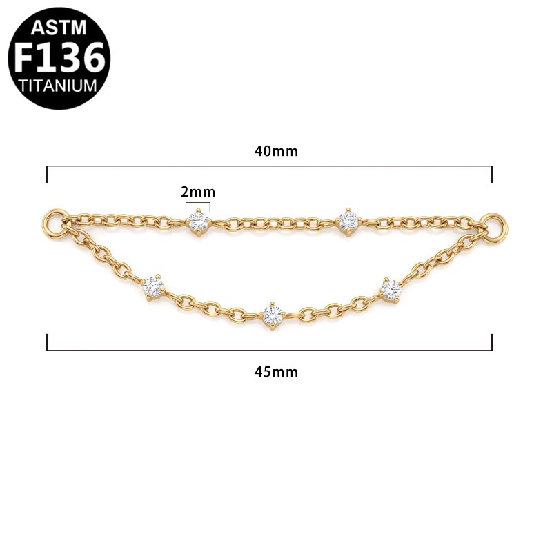 Gold chain with five clear round-cut stones, shown with dimension lines indicating a 40mm length, 2mm link spacing, and 45mm overall width.  ASTM F136 TITANIUM.