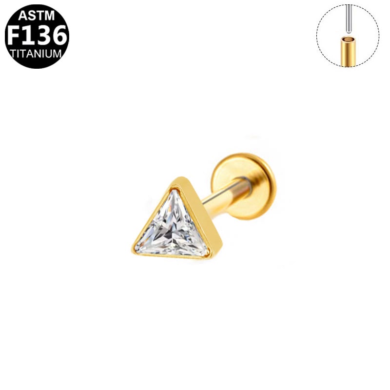 A gold-plated titanium triangle stud piercing earring with a clear faceted cubic zirconia gemstone, shown on a white background with an ASTM F136 titanium badge and a post diameter inset diagram.